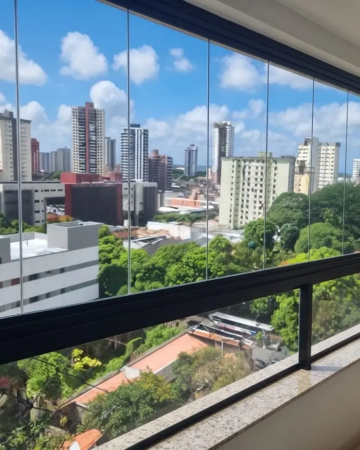 Sacada fechada com o sistema Reiki em Belém: vidros sem perfis verticais, com vista para prédios e árvores